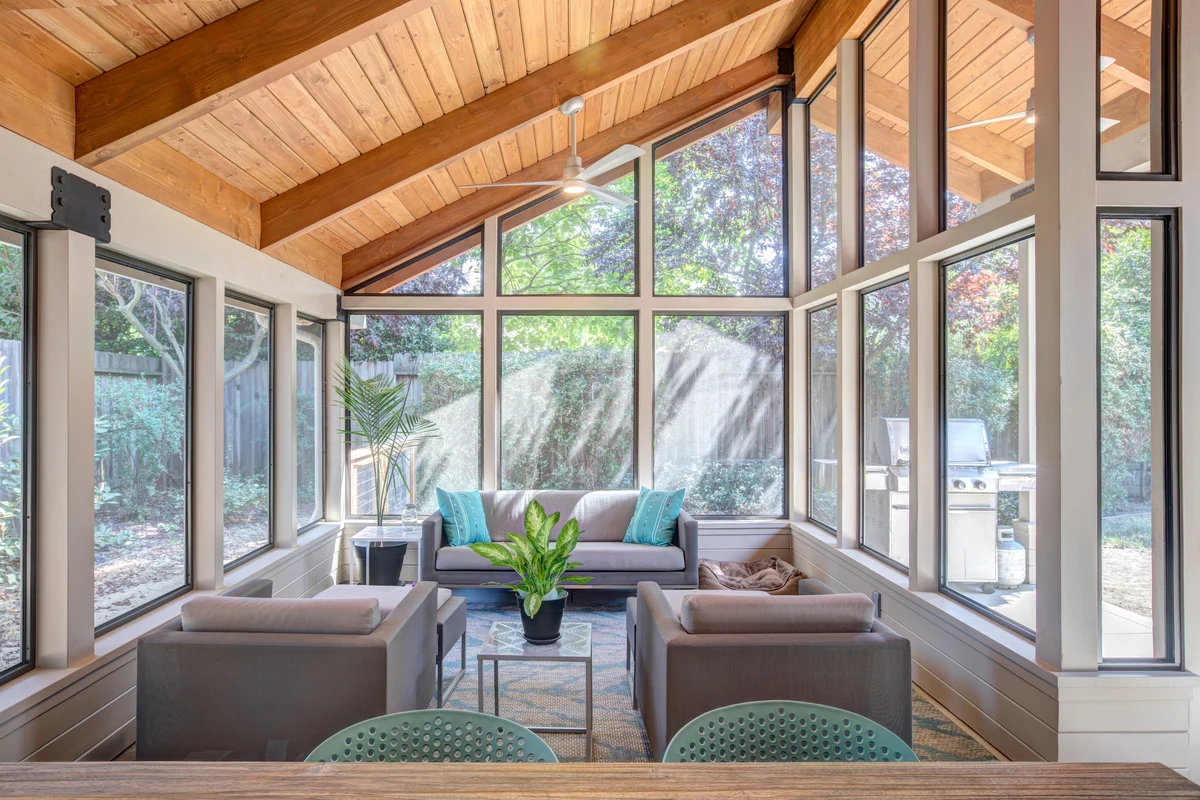 Glass-walled sunroom home addition with vaulted wood ceiling and seating area, Placer County