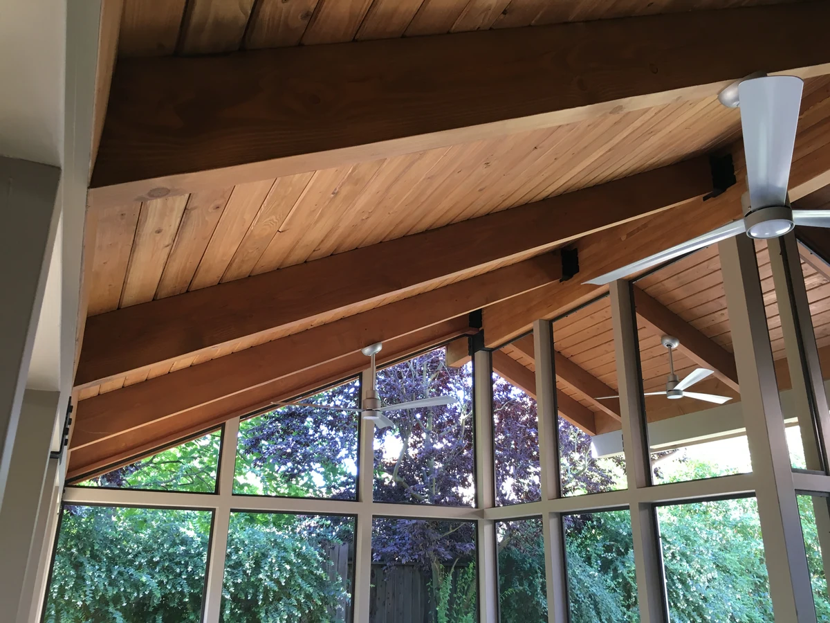 Exposed beam framing meeting the window wall in a sunroom home addition, Placer County